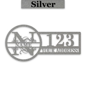 May include: Silver metal house number sign with a circle containing the letter N and the word "NAME" and a rectangle with the number 123 and the words "YOUR ADDRESS".