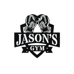 May include: Black and white logo with a heart-shaped shield. Two boxing gloves are crossed at the top of the shield. The text "JASON'S GYM" is on a banner below the shield.
