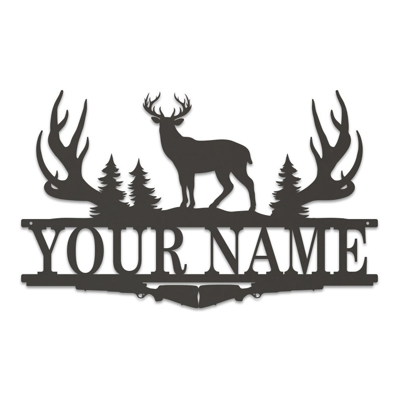 May include: Black metal silhouette of a deer with large antlers, standing in front of two pine trees. The deer is standing on a metal bar with the text "YOUR NAME" in black.