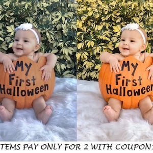 May include: A baby wearing a white headband sits inside a large orange pumpkin with the text "My First Halloween" printed on it. The baby is smiling and looking to the right. The pumpkin is sitting on a white fluffy surface.