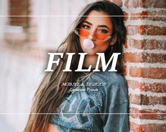 Op de afbeelding: Een vrouw draagt een blauw shirt met het woord "FILM" in witte tekst en de woorden "MOBILE & DESKTOP Lightroom Presets" in kleinere witte tekst. Ze draagt een oranje zonnebril en blaast een bel met roze kauwgom.