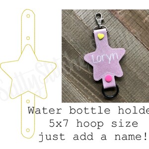 May include: Pink felt star-shaped water bottle holder with a black metal ring and a pink button. The holder has the name "Loryn" embroidered on it. The holder is 5x7 inches and can be personalized with a name.