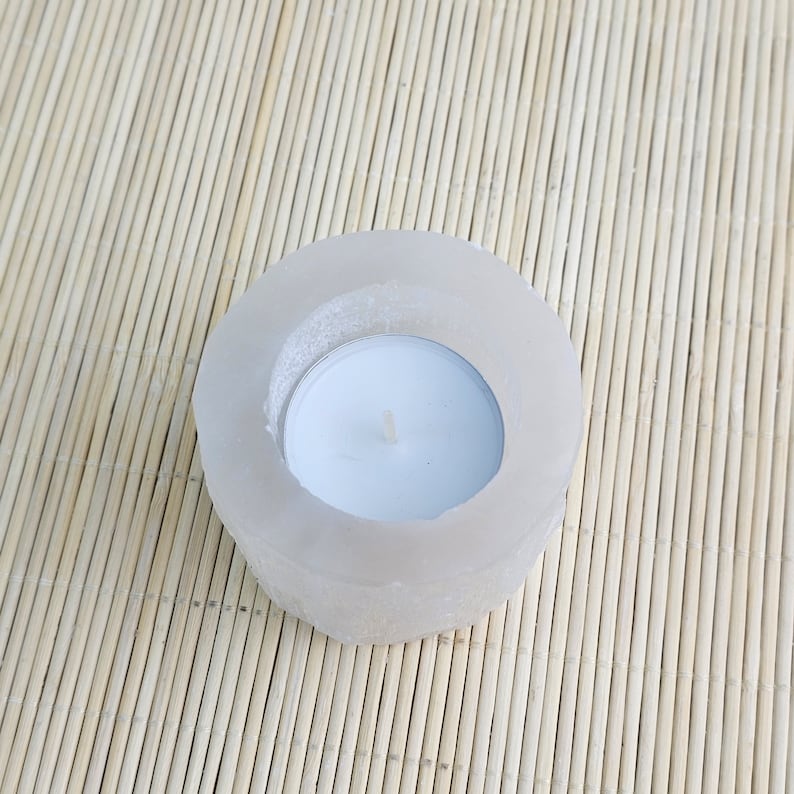 Pu&ograve; includere: Un portacandele di sale bianco di forma rotonda con una piccola candela tealight bianca all'interno.