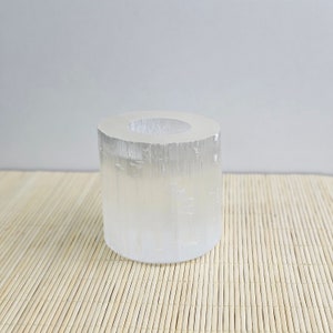 Pu&ograve; includere: Un portacandele in cristallo di selenite trasparente con forma cilindrica. Il portacandele &egrave; realizzato in selenite naturale e ha una superficie liscia e lucida.
