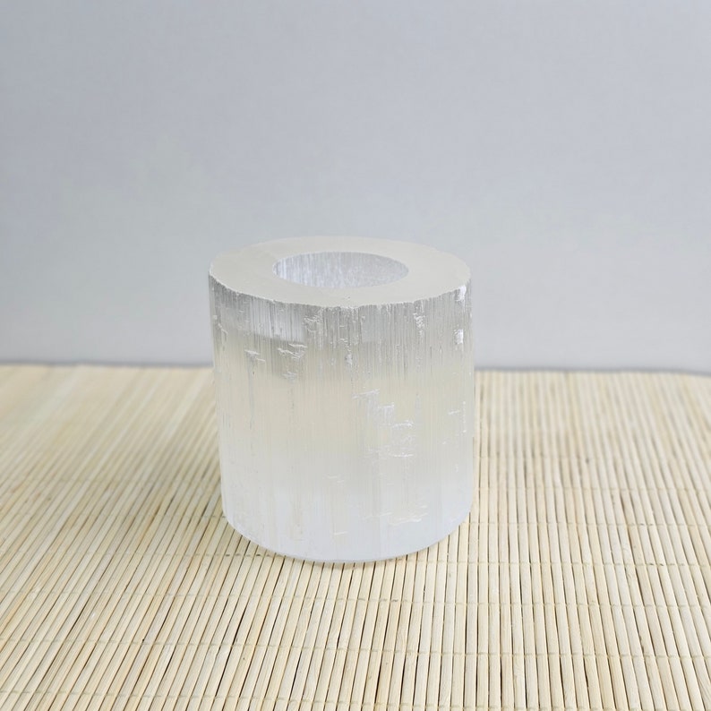 Pu&ograve; includere: Un portacandele in cristallo di selenite trasparente con forma cilindrica. Il portacandele &egrave; realizzato in selenite naturale e ha una superficie liscia e lucida.