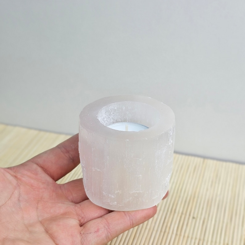 Pu&ograve; includere: Portacandele in selenite bianca con una piccola candela da t&egrave; bianca all'interno. Il portacandele &egrave; realizzato in cristallo di selenite naturale e ha una superficie ruvida e testurizzata.