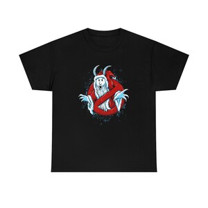 Op de afbeelding: Zwart T-shirt met een witte geest die een kerstmanmuts draagt ​​binnenin een rood "geen geest"-symbool. De geest heeft een witte baard en draagt ​​een rood pak. De achtergrond is zwart met witte sneeuwvlokken.