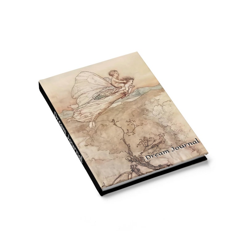 May include: A dream journal with a black cover and a vintage illustration of a fairy carrying a child. The text "Dream Journal" is printed on the cover.