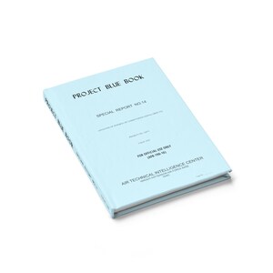 Puede incluir: Un libro azul claro titulado "PROJECT BLUE BOOK" con el texto "SPECIAL REPORT NO. 14" y "FOR OFFICIAL USE ONLY". El libro está ligeramente inclinado, mostrando su portada y lomo. La portada también incluye el texto "AIR TECHNICAL INTELLIGENCE CENTER".