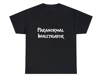 Może przedstawiać: Czarny t-shirt z białym napisem "Paranormal Investigator" w stylizowanej czcionce. Koszulka ma okrągły dekolt i wydaje się być wykonana z miękkiego materiału. Tekst jest wyśrodkowany na przodzie koszulki.