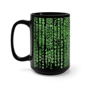 May include: A black ceramic mug with a green digital pattern of numbers and symbols. The mug has a large handle and is a standard size.