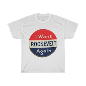 Könnte beinhalten: Weißes T-Shirt mit einem kreisförmigen Aufdruck mit dem Text "I Want ROOSEVELT Again" in Rot, Weiß und Blau. Das Design erinnert an eine Wahlkampfabzeichen. Das Shirt ist aus einem weichen, bequemen Material.