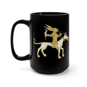 May include: Black ceramic mug with a white background featuring a medieval illustration of a rabbit riding a dog.