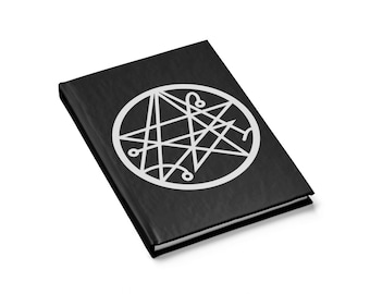Op de afbeelding: Een zwart notitieboek met een wit pentagram symbool op de omslag.
