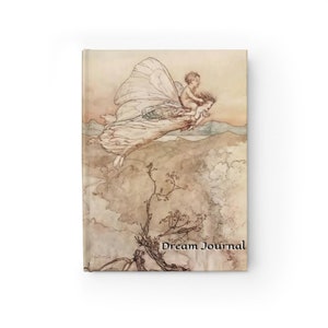 May include: A vintage illustration of a fairy with large wings flying through the air with a small child riding on her back. The fairy is wearing a long white dress and the child is wearing a simple tunic. The background is a soft, muted landscape with hills and trees. The text "Dream Journal" is printed at the bottom of the image.