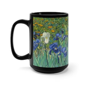 May include: Black coffee mug with a white rim and handle. The mug features a colorful painting of blue, white, and yellow irises against a green background.