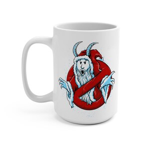 Op de afbeelding: Witte keramische koffiemok met een rode en witte illustratie van een geest die een kerstmanmuts en een rood-wit gestreept pak draagt. De geest bevindt zich in een rode cirkel met een diagonale streep erdoorheen.