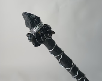 May include: Black wand with a black crystal tip and black stones wrapped around the base of the tip with silver wire.