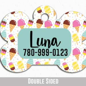 May include: White bone-shaped dog tag with a colourful ice cream pattern. The tag has a turquoise rectangle with the name "Luna" and the phone number "780-999-0123". The tag is double-sided.