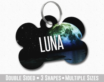 May include: A black and blue bone-shaped dog tag with a green and blue moon image and the word "LUNA" in white text.