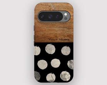 Op de afbeelding: Een telefoonhoesje met een houten bovenkant en een zwarte onderkant. Het houten gedeelte heeft een natuurlijk houtnerfpatroon. De onderkant heeft een patroon van zilverkleurige cirkels op een zwarte achtergrond. De tekst "Your Name" staat op het hout.