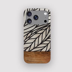 May include: A phone case with a wood grain design. The top portion features a light wood grain pattern with black leaf-like lines. The bottom section is a darker wood grain. The text "Your Name" is printed on the bottom.