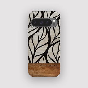 May include: A phone case featuring a black leaf design on a light wood grain background. The lower section is a darker wood grain with the engraved text "Your Name".