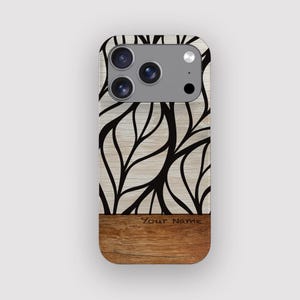 Peut inclure: Coque de téléphone avec un motif imitation bois. La partie supérieure présente un motif clair avec des motifs noirs en forme de feuilles. La partie inférieure est un grain de bois plus foncé avec le texte "Your Name".
