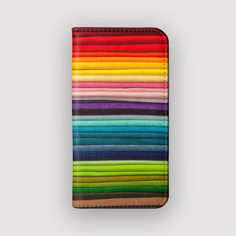 Pode incluir: Uma capa de telefone colorida com um padr&atilde;o de arco-&iacute;ris de listras horizontais. A capa &eacute; de couro e tem uma borda costurada.