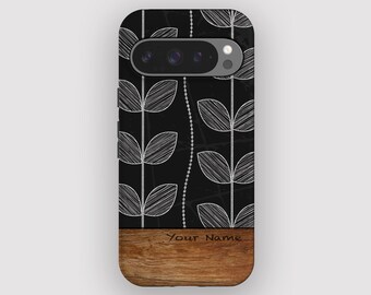 Puede incluir: Funda de teléfono negra con un diseño de hojas blancas y una base de madera. La funda tiene un recorte para la cámara y el texto "Your Name" en la madera. El diseño presenta un patrón de hojas verticales.