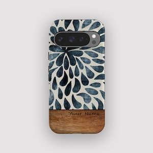 May include: A phone case with a floral design in shades of blue and white. The top portion features a pattern of stylized teardrops, while the bottom has a wooden finish. The text "Your Name" is printed on the wood.