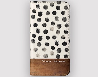 May include: A white phone case with a black polka dot pattern. The bottom section is brown with the text "Your Name" printed in white. The case is rectangular and appears to be made of leather or a similar material.