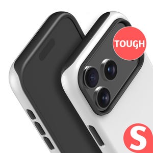 a white and black smartphone with a red "TOUGH" sticker on the back.