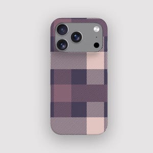 May include: A mobile phone case featuring a plaid design in shades of purple, pink, and white. The case has a camera module with three lenses and a flash. The pattern is a repeating arrangement of squares and diagonal stripes.