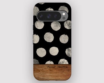 Op de afbeelding: Zwarte telefoonhoes met een patroon van zilvergrijze cirkels. Het onderste gedeelte heeft een houtnerftextuur met de tekst "Your Name". De telefoonhoes heeft een camera-uitsparing.