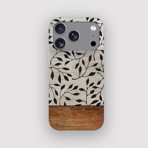 Op de afbeelding: Een telefoonhoesje met een houtnerf ontwerp. Het bovenste gedeelte heeft een lichte houtnerf achtergrond met zwarte blad- en rankpatronen. Het onderste gedeelte is een donkerdere houtnerf. De tekst "Your Name" staat onderaan.