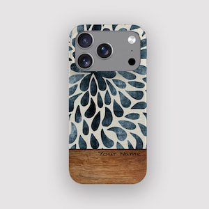 Puede incluir: Funda de teléfono con diseño floral. La parte superior presenta un patrón de gotas azules sobre un fondo crema. La sección inferior tiene una apariencia de vetas de madera con el texto "Your Name".