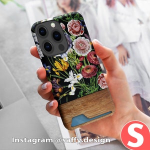 a woman holding up a phone case with flowers on it