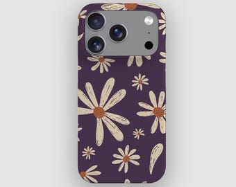 May include: A phone case featuring a daisy design. The case is dark purple with a repeating pattern of beige daisies with brown centres. The phone case has a camera cut-out and is designed to fit a smartphone.