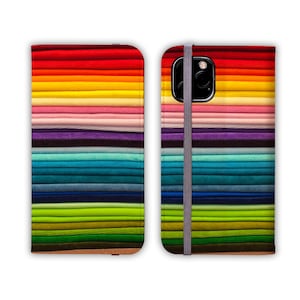 Pode incluir: Uma capa de telefone colorida com um padr&atilde;o de arco-&iacute;ris de listras horizontais. A capa &eacute; feita de um material dur&aacute;vel e possui um suporte embutido para visualiza&ccedil;&atilde;o com as m&atilde;os livres.