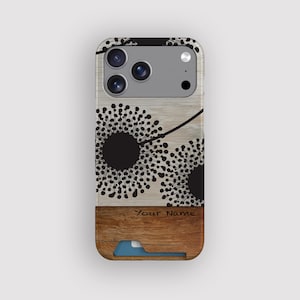 May include: A phone case with a wood grain design and a black floral pattern. The case has a brown lower section with the text "Your Name" and a blue card holder. The phone's camera lenses are visible at the top.