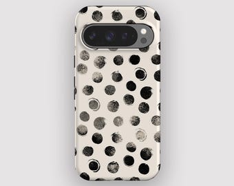 Op de afbeelding: Een telefoonhoesje met een crèmekleurige achtergrond en een patroon van zwarte en grijze stippen. De hoes heeft een camera-uitsparing en is ontworpen voor een smartphone. De stippen variëren in grootte en textuur, wat een uniek ontwerp creëert.