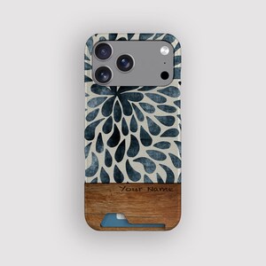 Könnte beinhalten: Smartphone-Hülle mit blau-weißem Blumenmuster. Der untere Teil hat eine Holzoptik, einen Kartensteckplatz und den Text "Your Name". Die Hülle hat ein Kameramodul mit drei Linsen.