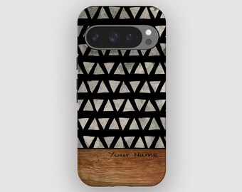 Puede incluir: Una funda de teléfono con fondo negro y un patrón de triángulos blancos. La sección inferior tiene un aspecto de veta de madera. El texto "Your Name" está impreso en la sección de veta de madera.