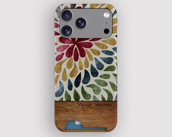 May include: A phone case with a colorful floral design. The case features a pattern of teardrop-shaped petals in shades of red, yellow, blue, and green. The bottom portion has a wood-grain texture with the text "Your Name".