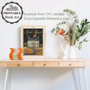 Peut inclure: Une impression encadr&eacute;e d'une page de livre vintage avec une illustration d'une maison avec une fen&ecirc;tre &eacute;clair&eacute;e la nuit. Le texte sur la page indique "Jane Eyre" et "Charlotte Bronte". L'impression est sur un bureau en bois avec une pile de livres et un vase de fleurs s&eacute;ch&eacute;es.