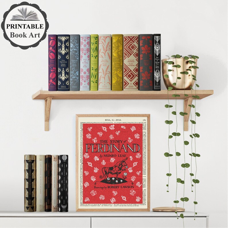 Peut inclure: Art d'impression de livre avec une illustration rouge et blanche d'un taureau du livre pour enfants "L'histoire de Ferdinand" de Munro Leaf. L'illustration est entour&eacute;e d'un fond rouge avec des fleurs blanches et du texte.