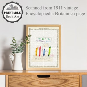 May include: A framed print featuring a vintage encyclopedia page with the text "Crayon-Cr&egrave;millon." The artwork depicts colorful crayons holding signs that read "The Day the Crayons Quit." The print is in a wooden frame and is displayed on a wooden surface.