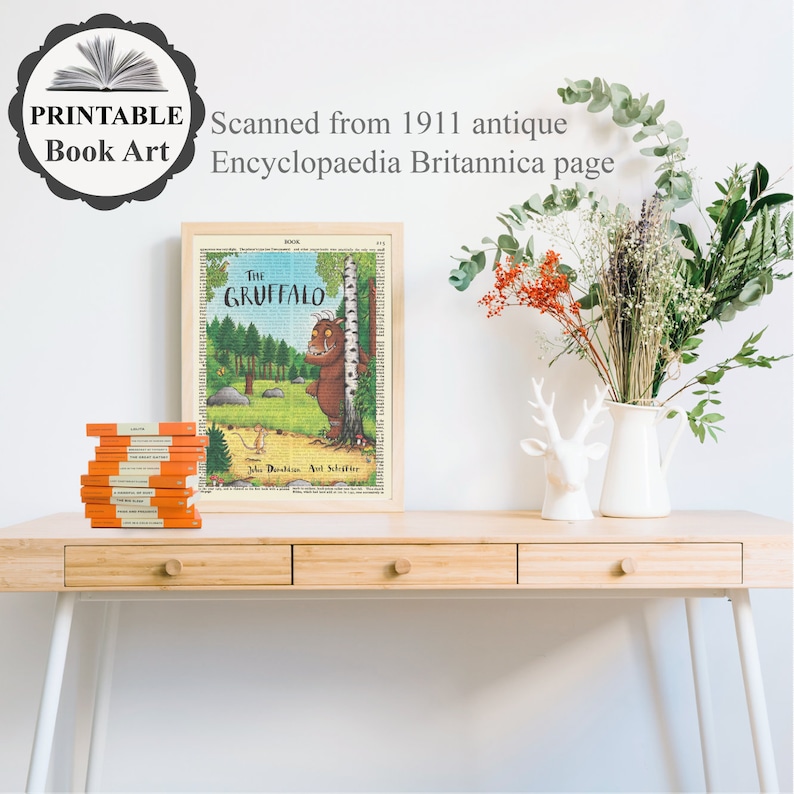 Pu&ograve; includere: Una stampa incorniciata di un'illustrazione di un libro per bambini che presenta un mostro verde e peloso con grandi orecchie e un naso lungo. Il titolo del libro &egrave; "The Gruffalo" e la stampa &egrave; su uno sfondo vintage in stile giornale. La stampa &egrave; su una scrivania di legno con una pila di libri e un vaso di fiori.