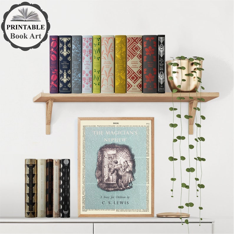 Op de afbeelding: Een printbare boekkunstprint met een vintage illustratie van een boekomslag voor "The Magician's Nephew" van C.S. Lewis. De print is ingelijst en wordt tentoongesteld op een plank met een potplant en een rij boeken.